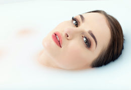 Woman wearing a button-down shirt, taking a bath