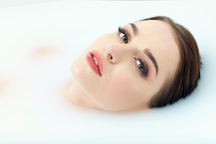 Woman wearing a button-down shirt, taking a bath