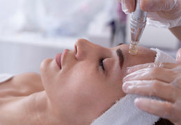 microneedling tools laid out on a pink background