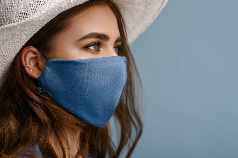 Woman looking to the side and wearing a blue face mask