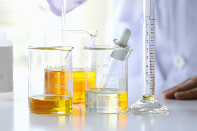 Lab beakers filled with oil and dropper